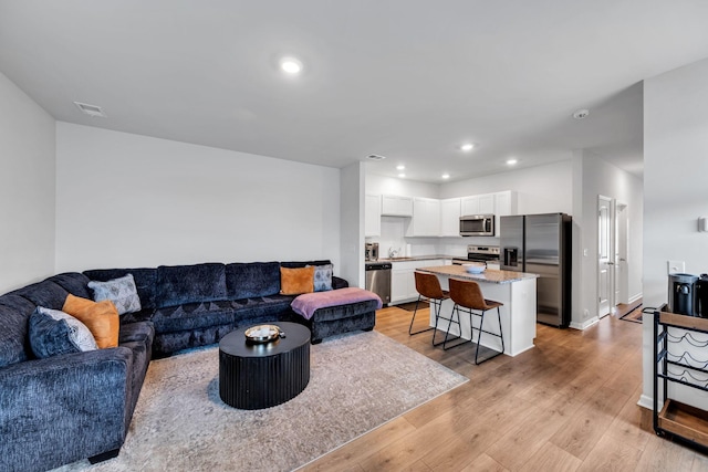 living room with sink and light wood-type flooring