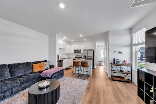 living room with sink and light wood-type flooring