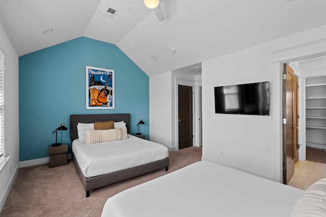 bedroom featuring vaulted ceiling, a spacious closet, light carpet, and ceiling fan