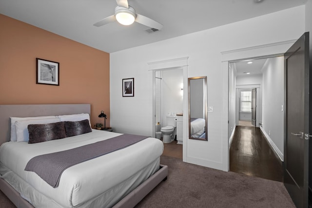 bedroom featuring dark hardwood / wood-style flooring, ceiling fan, and ensuite bathroom