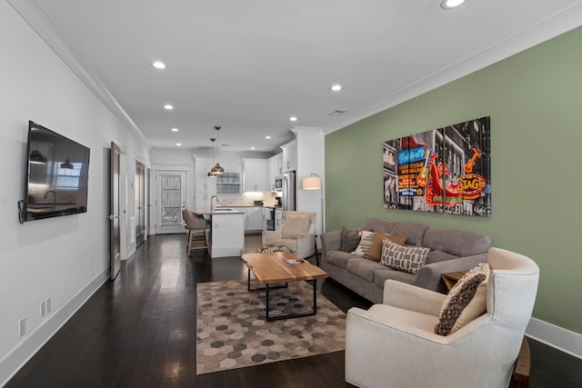 living room featuring crown molding, dark wood-type flooring, and sink