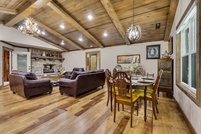 dining area featuring a stone fireplace, wooden ceiling, lofted ceiling with beams, a notable chandelier, and light hardwood / wood-style flooring