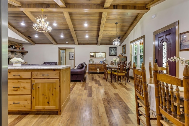 kitchen featuring hanging light fixtures, an inviting chandelier, wooden ceiling, and vaulted ceiling with beams