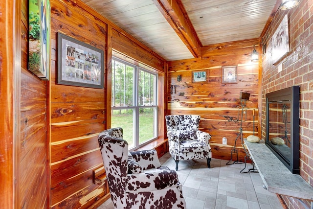 living area with beamed ceiling, wood walls, and a healthy amount of sunlight