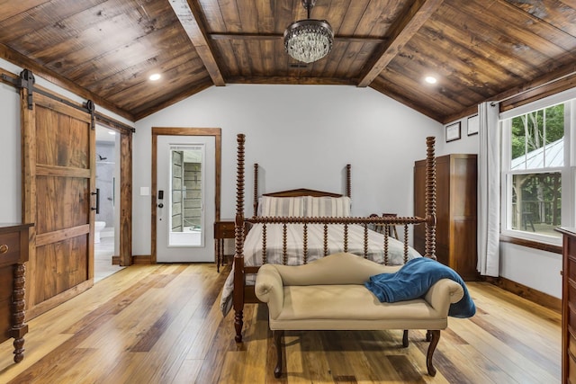 bedroom with light hardwood / wood-style floors, vaulted ceiling with beams, connected bathroom, and a barn door