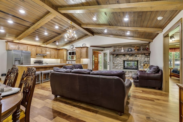 living room featuring a stone fireplace, wooden ceiling, light wood-type flooring, vaulted ceiling with beams, and a notable chandelier