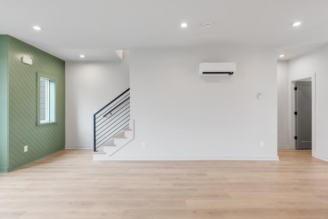 interior space with light hardwood / wood-style floors and an AC wall unit