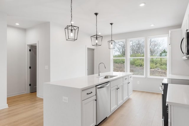 kitchen featuring sink, an island with sink, white cabinetry, and stainless steel appliances