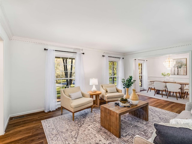 living room featuring a chandelier, ornamental molding, and dark hardwood / wood-style floors