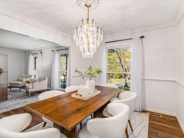 dining space featuring crown molding, hardwood / wood-style flooring, and a notable chandelier