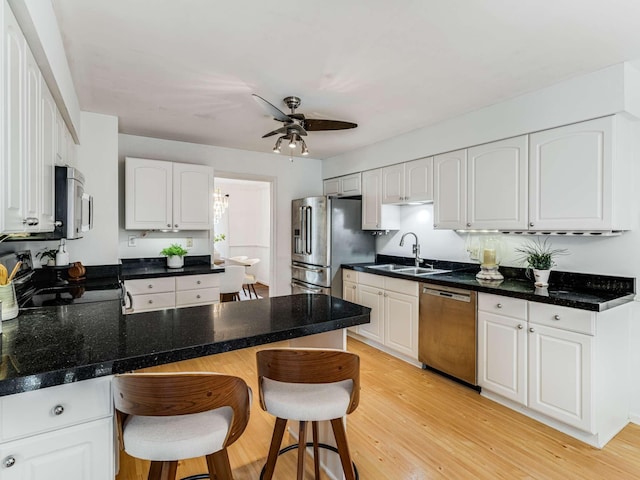 kitchen with stainless steel appliances, a breakfast bar area, and white cabinets