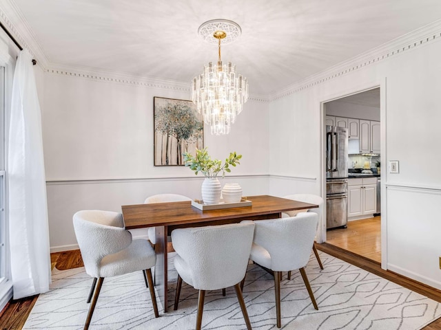 dining room with a chandelier, light hardwood / wood-style floors, and crown molding