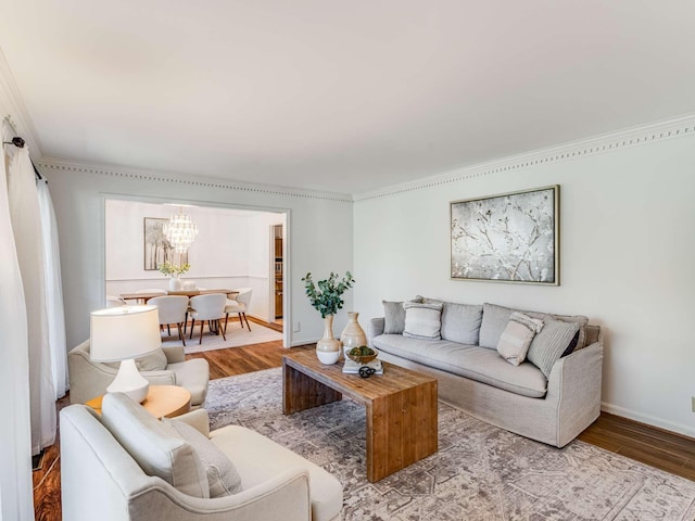 living room with ornamental molding, a notable chandelier, and hardwood / wood-style floors