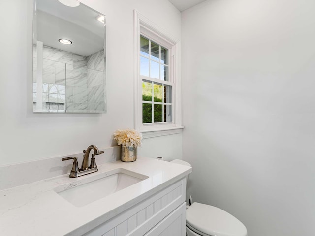 bathroom featuring toilet, a shower with door, and vanity