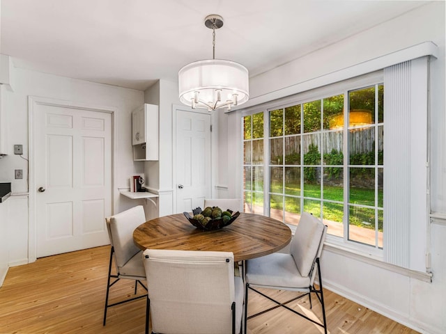 dining space featuring light hardwood / wood-style floors and a chandelier