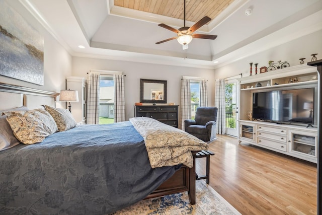 bedroom with ceiling fan, wood ceiling, light hardwood / wood-style flooring, and a tray ceiling