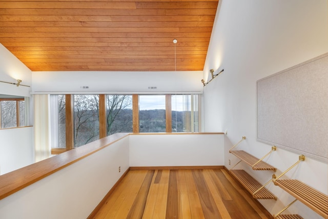 spare room featuring light wood-type flooring, vaulted ceiling, and wood ceiling