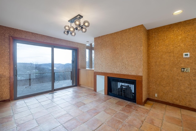 unfurnished living room featuring a notable chandelier and a mountain view