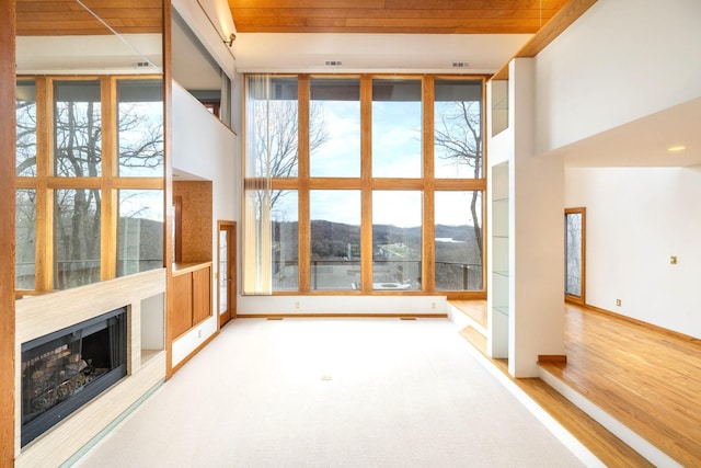 interior space with wood ceiling, a mountain view, and plenty of natural light