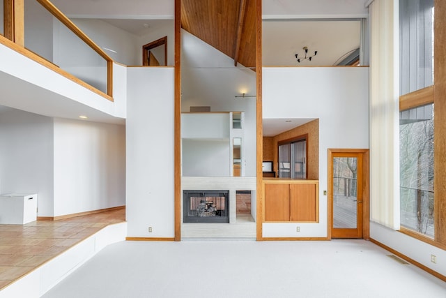 unfurnished living room with a towering ceiling and tile patterned floors