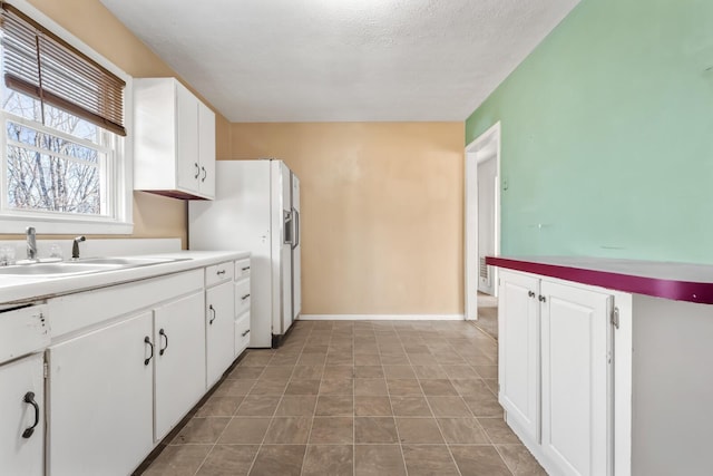 kitchen featuring sink, a textured ceiling, and white cabinetry