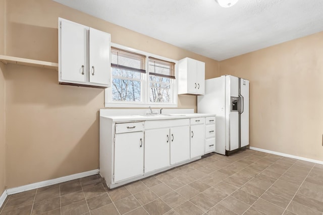 kitchen featuring white appliances, white cabinetry, and sink