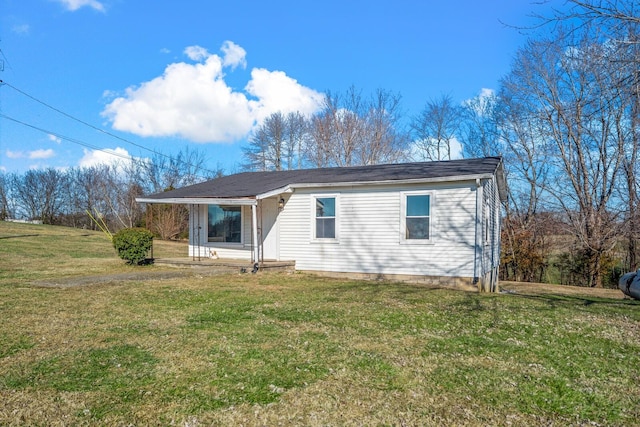 rear view of house with covered porch and a yard