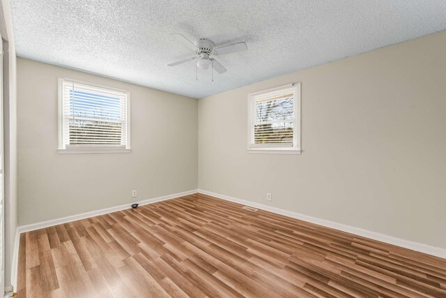 empty room featuring a textured ceiling, ceiling fan, and light hardwood / wood-style flooring