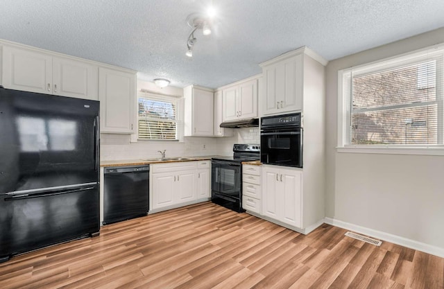 kitchen featuring black appliances, white cabinets, a textured ceiling, and sink