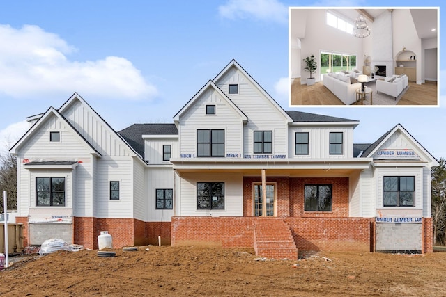 view of front facade with an outdoor living space, board and batten siding, and brick siding