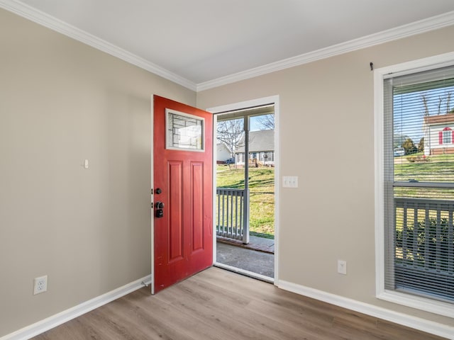 foyer entrance featuring ornamental molding and light hardwood / wood-style flooring