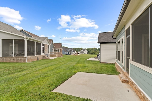 view of yard with a sunroom and a patio