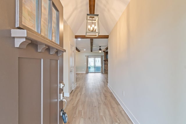 foyer featuring ceiling fan with notable chandelier, lofted ceiling with beams, and hardwood / wood-style floors