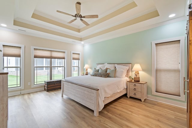 bedroom featuring ceiling fan, light hardwood / wood-style floors, and a raised ceiling