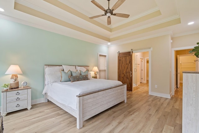 bedroom with ornamental molding, a raised ceiling, and a barn door