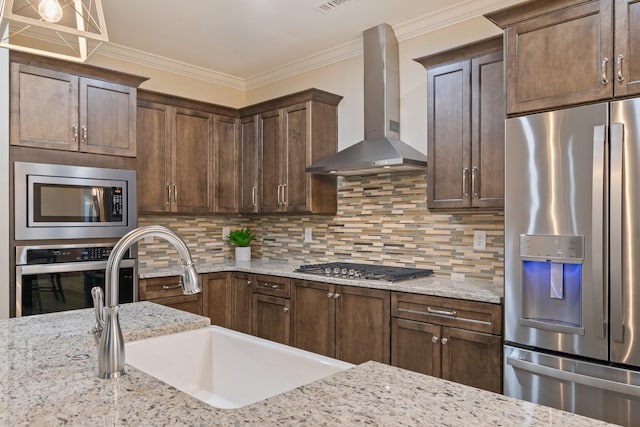 kitchen with stainless steel appliances, crown molding, sink, wall chimney range hood, and tasteful backsplash