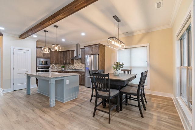 dining space with light hardwood / wood-style floors, ornamental molding, sink, and beam ceiling