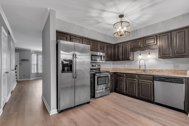 kitchen with a chandelier, stainless steel appliances, dark brown cabinetry, sink, and decorative light fixtures