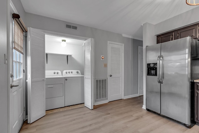 washroom with light hardwood / wood-style floors and washer and clothes dryer