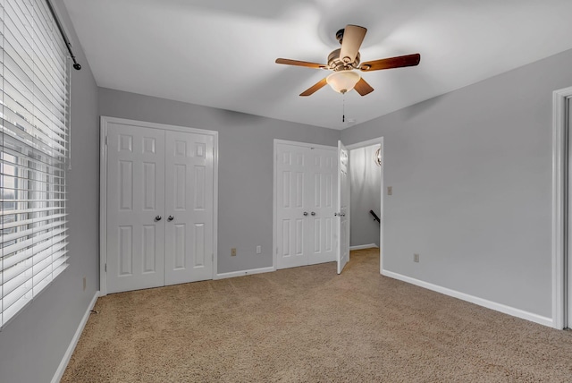 unfurnished bedroom featuring two closets and ceiling fan