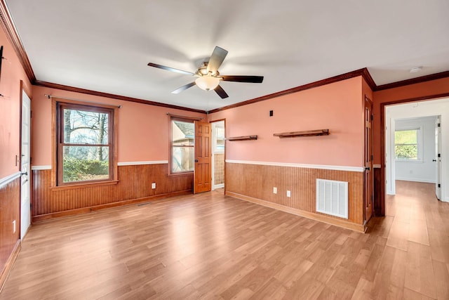 unfurnished room with ceiling fan, a wealth of natural light, and ornamental molding