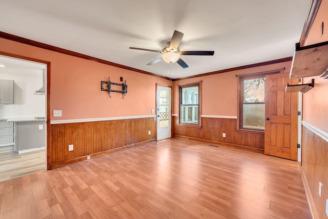 empty room featuring ceiling fan, ornamental molding, and light hardwood / wood-style flooring