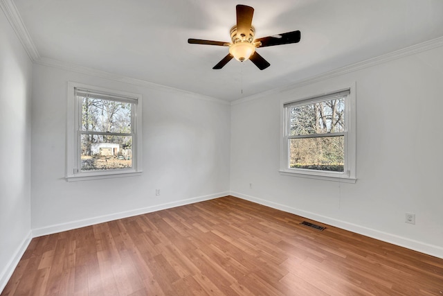 empty room with a healthy amount of sunlight, ceiling fan, and light hardwood / wood-style flooring