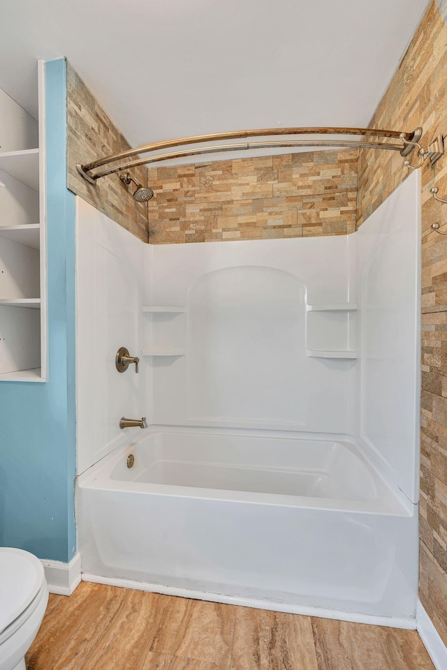 bathroom with toilet and washtub / shower combination