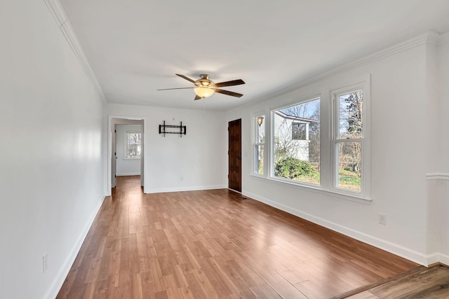 empty room with ceiling fan, crown molding, and light hardwood / wood-style floors