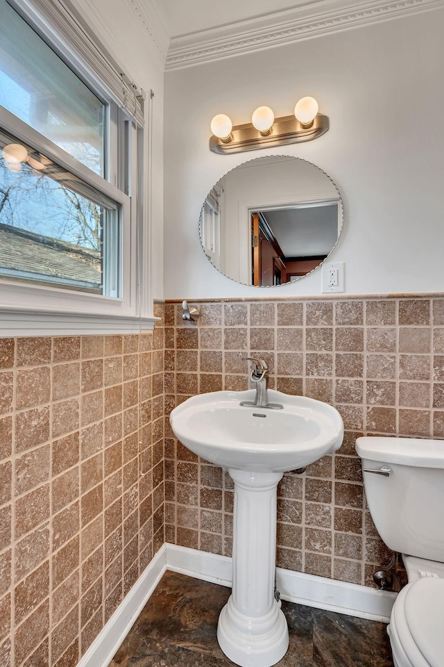 bathroom featuring tile walls, ornamental molding, and toilet