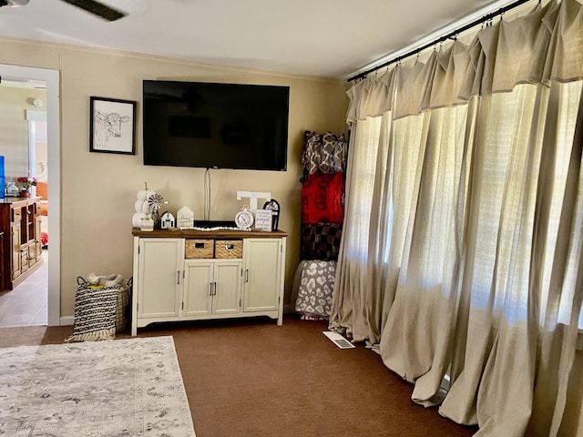 bedroom featuring ornamental molding and dark carpet