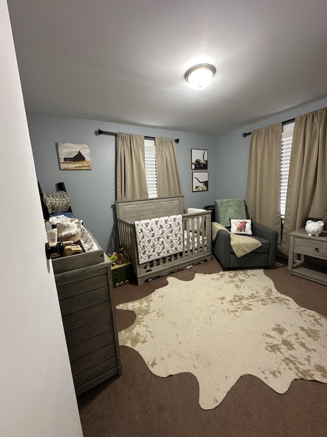 carpeted bedroom featuring a nursery area