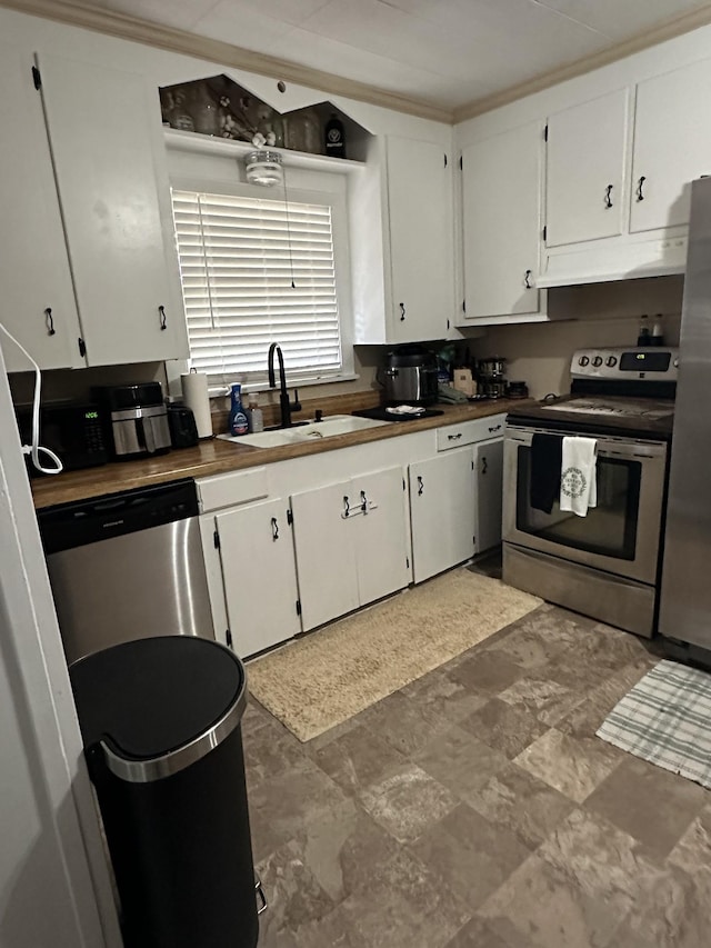 kitchen featuring stainless steel appliances, white cabinets, ornamental molding, and sink