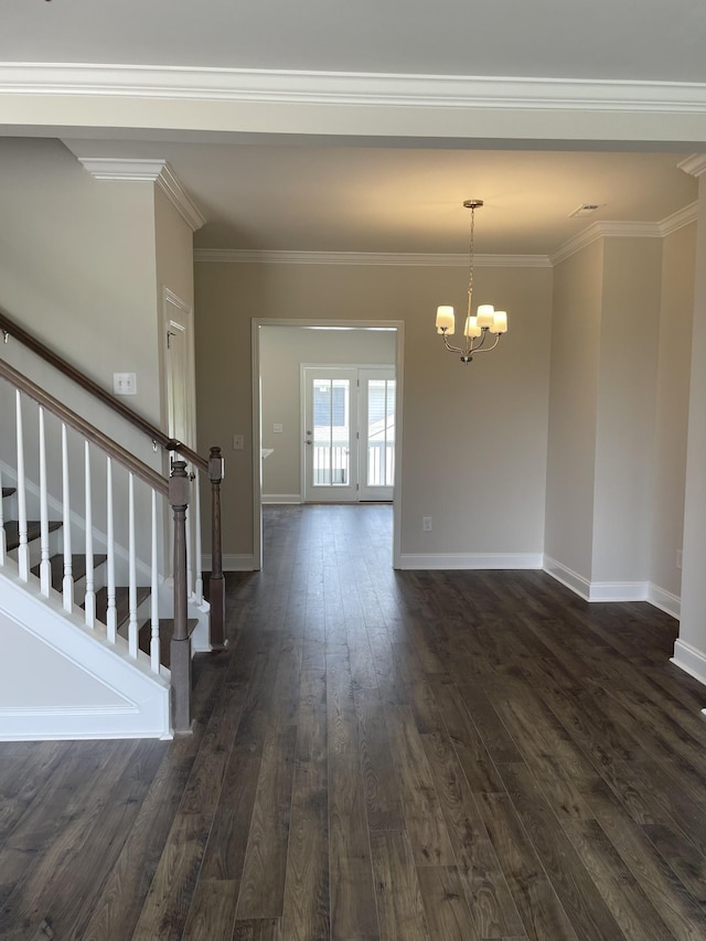 empty room featuring a chandelier, ornamental molding, and dark hardwood / wood-style floors